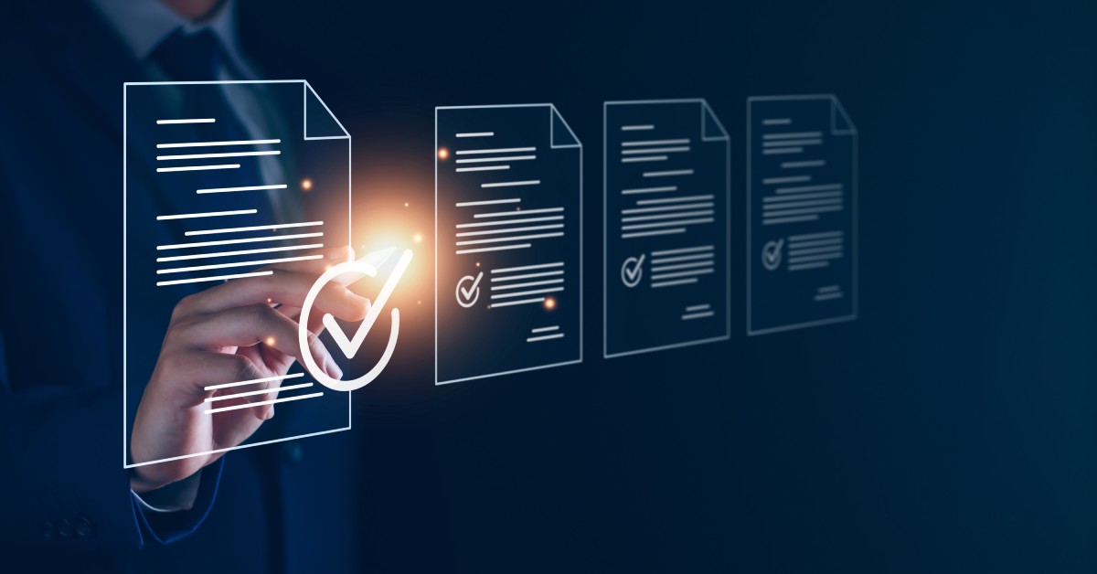 A business person wearing a suit looks at holographic icons of documents and selects the first one.